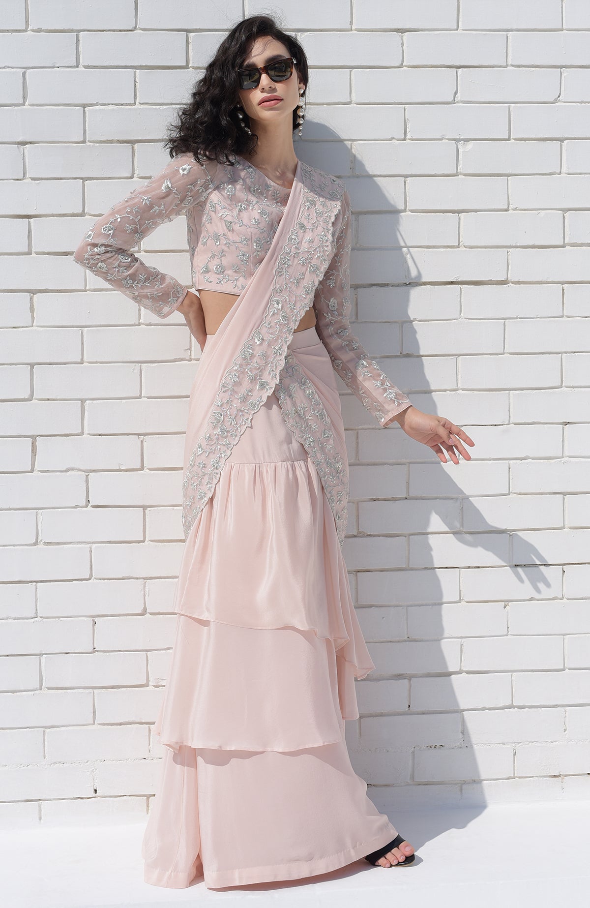 Nude pink saree with silver floral embroidery and scalloped borders, paired with embroidered blouse.