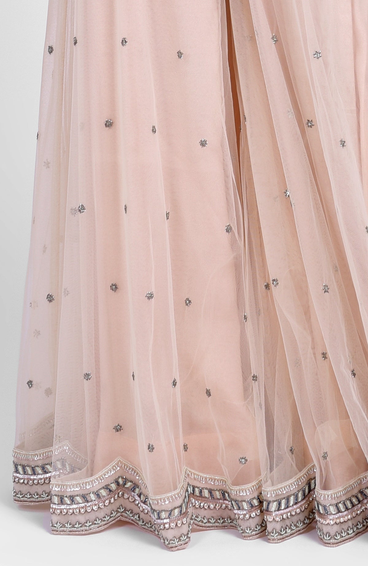Champagne pink sharara set with bead sequins, hand embroidery, and tulle dupatta with jeweled choker.