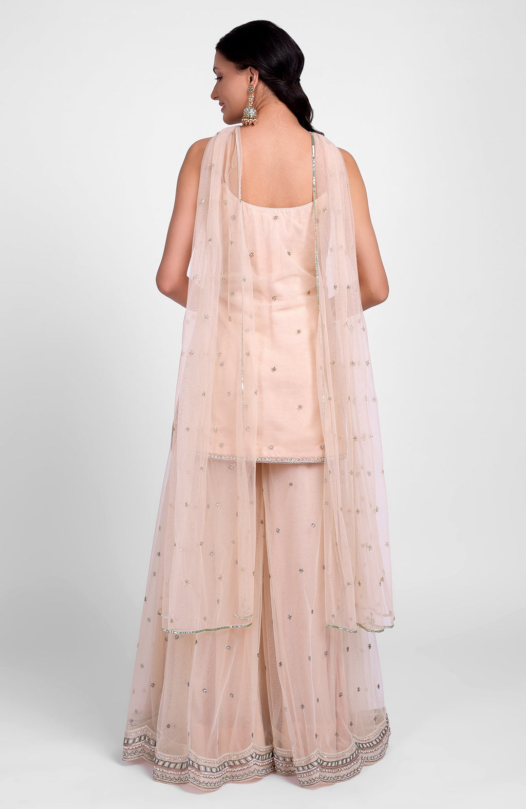 Champagne pink sharara set with bead sequins, hand embroidery, and a jeweled tulle dupatta.