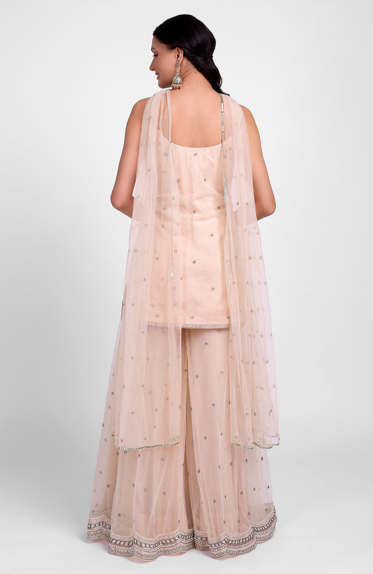 Champagne pink sharara set with bead sequins, hand embroidery, and a jeweled tulle dupatta.