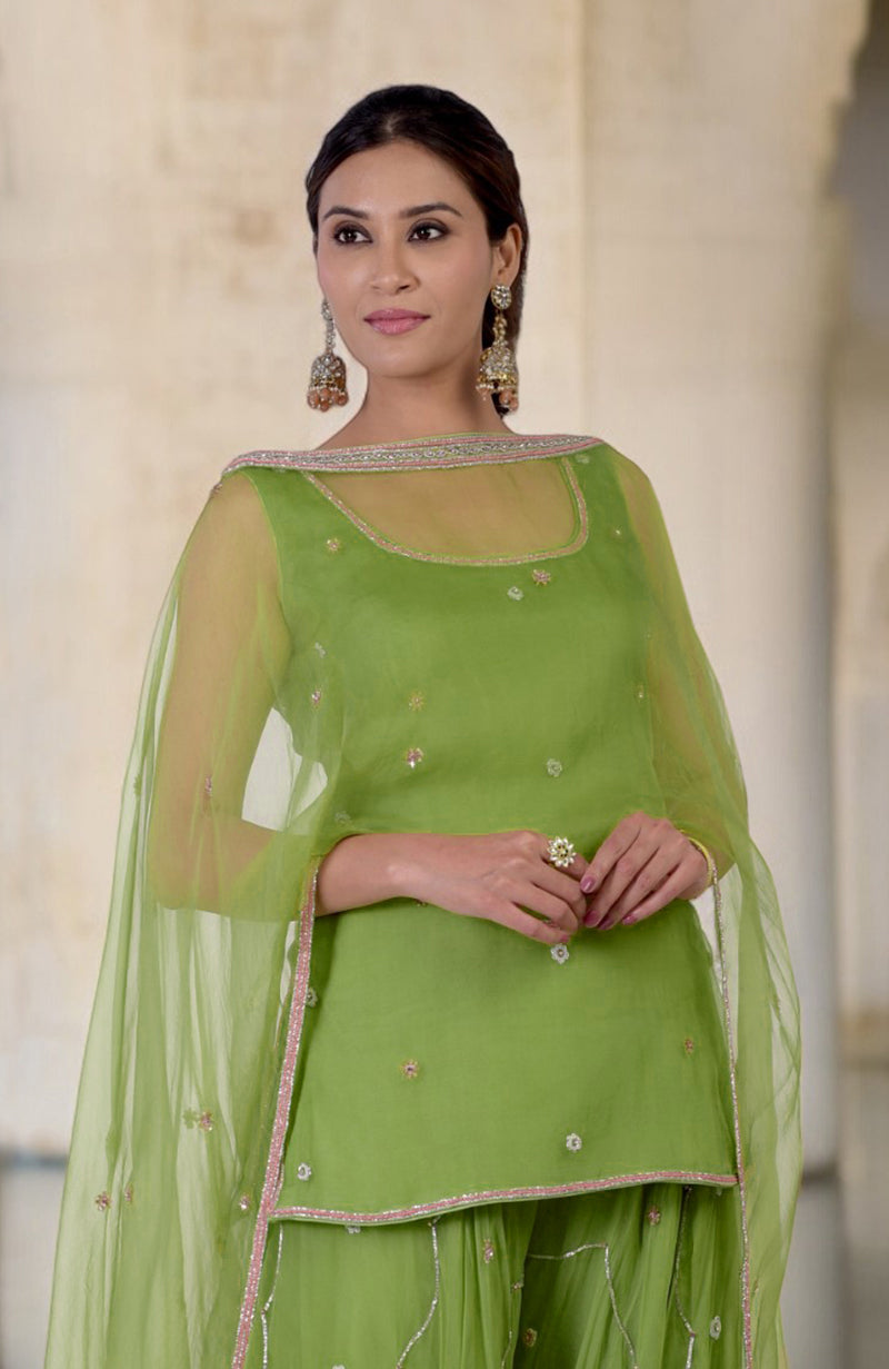 A woman models a lime green hand-embroidered sharara cape set with a scoop neck.