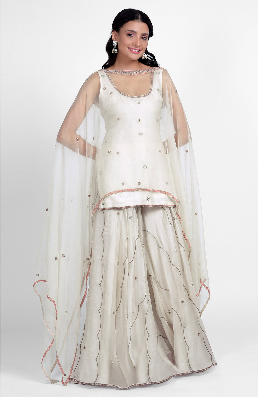 Off-white silk organza sharara set with pastel embroidery, scoop neck kurta, and cape dupatta