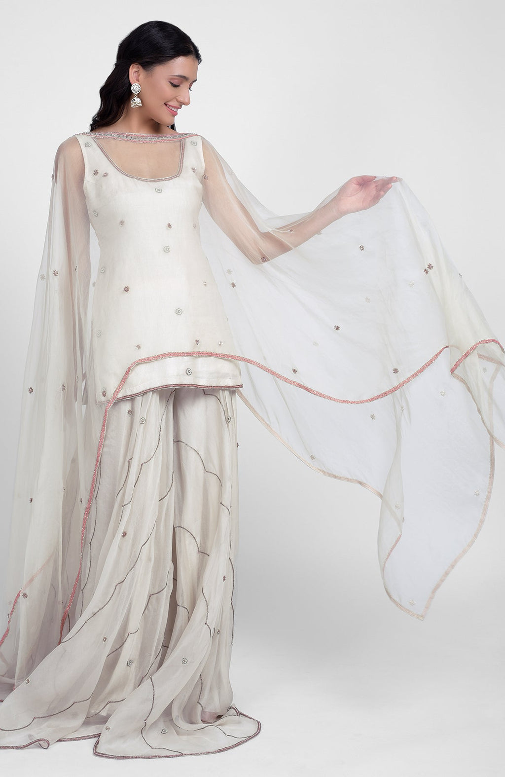Off-white silk organza sharara set with pastel hand embroidery, scoop neck kurta, and cape dupatta