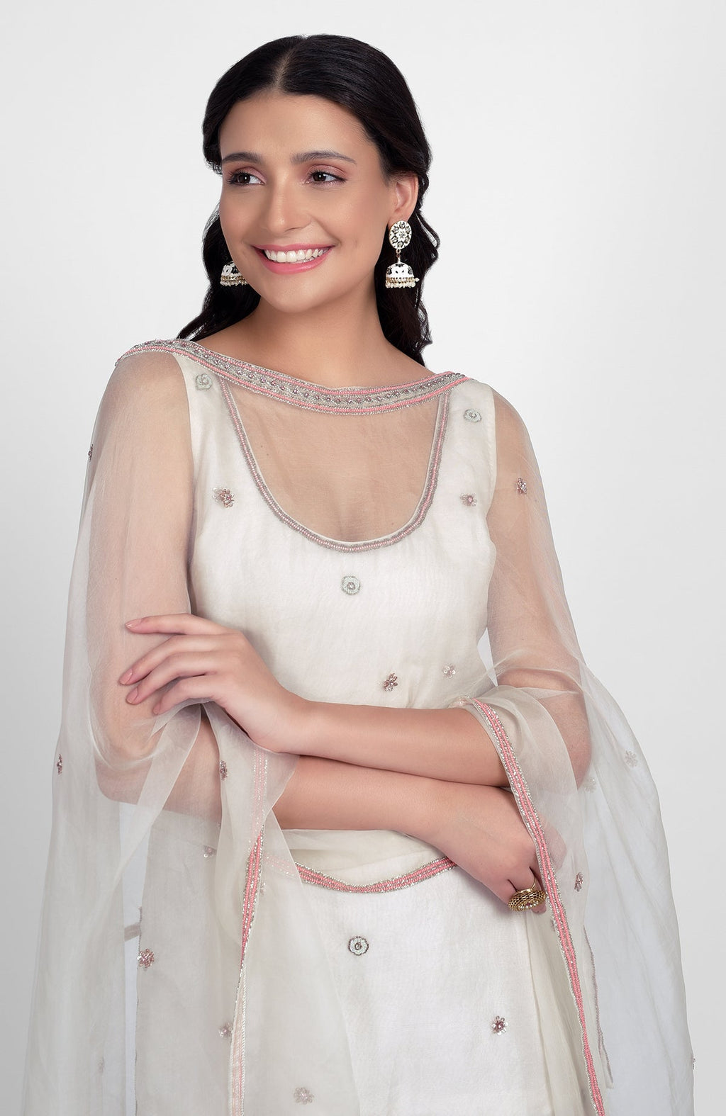 Off-white silk organza sharara set with pastel embroidery, scoop neck kurta, and cape dupatta
