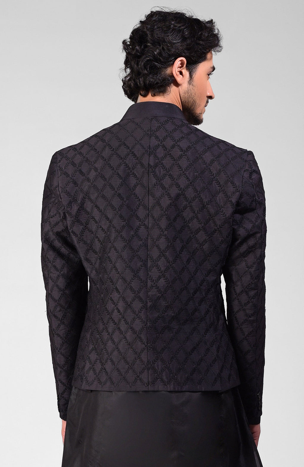 Black silk Bandhgala jacket with intricate chikankari embroidery in a three-piece set.