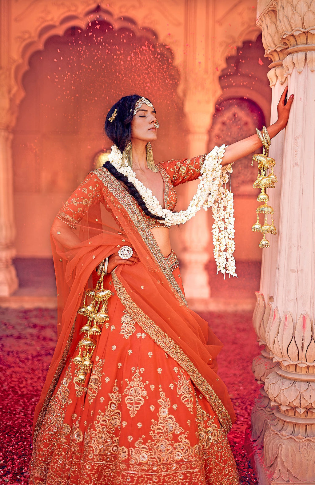 Red lehenga set with gold floral embroidery, sweetheart neckline, open back, and flared skirt.