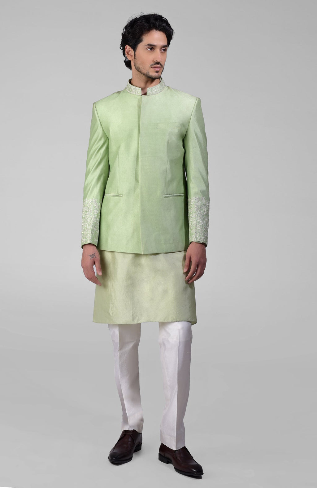 Sage green three-piece silk set with embroidered bandhgala jacket, kurta, and pants.