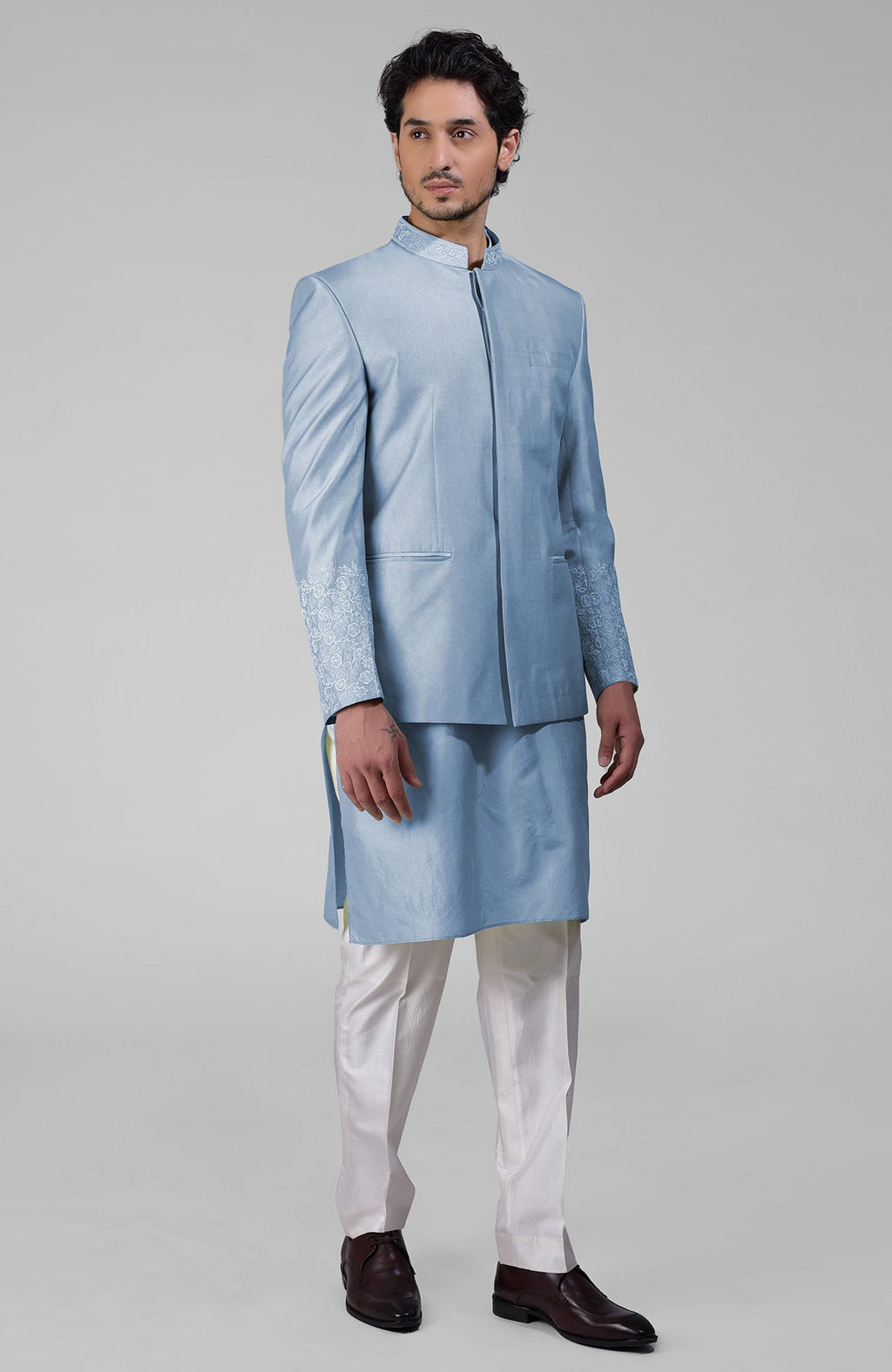 Dusty blue silk three-piece set with embroidered bandhgala jacket, kurta, and pants.