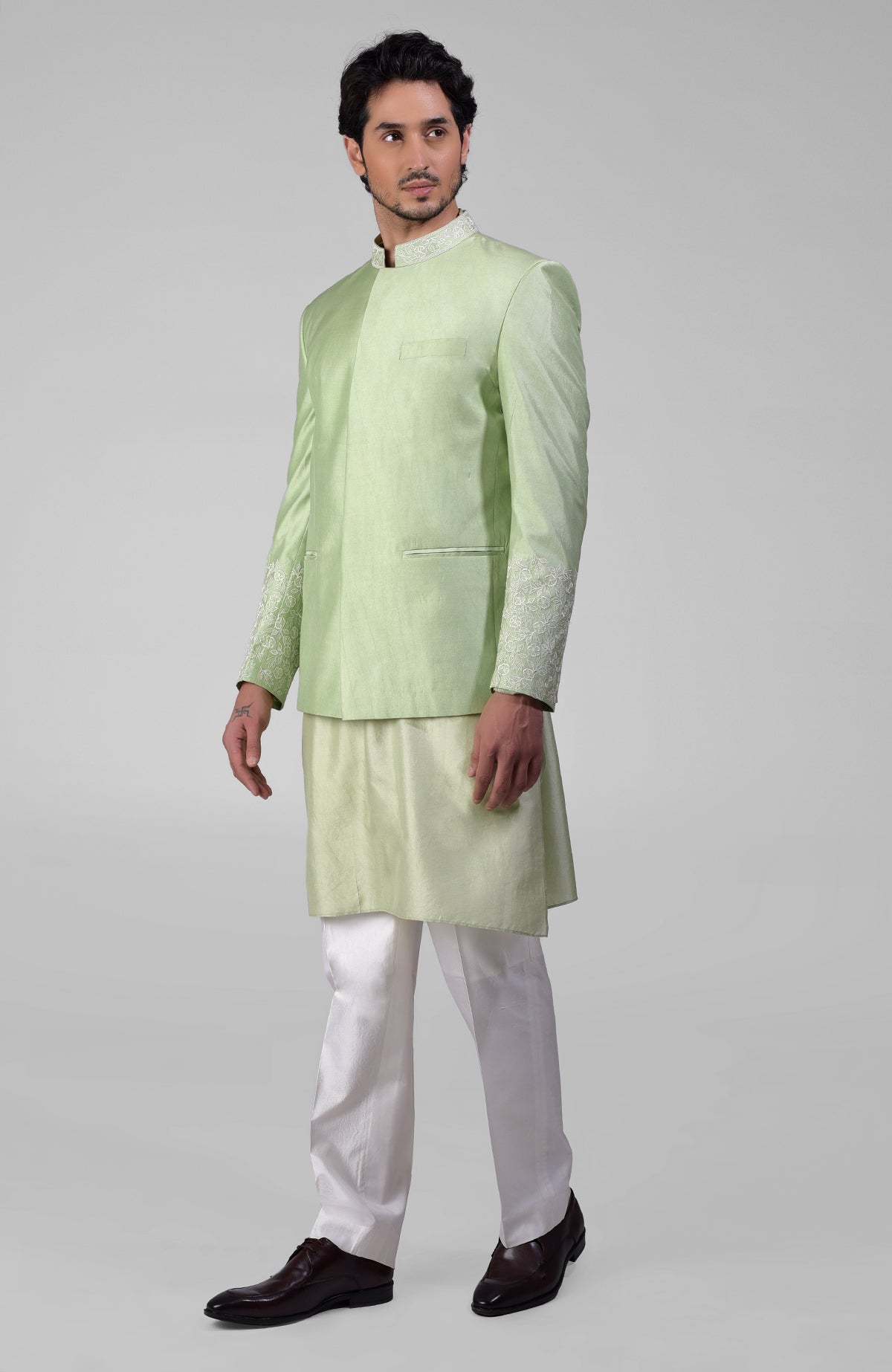Sage green three-piece silk set with embroidered bandhgala jacket, kurta, and pants.