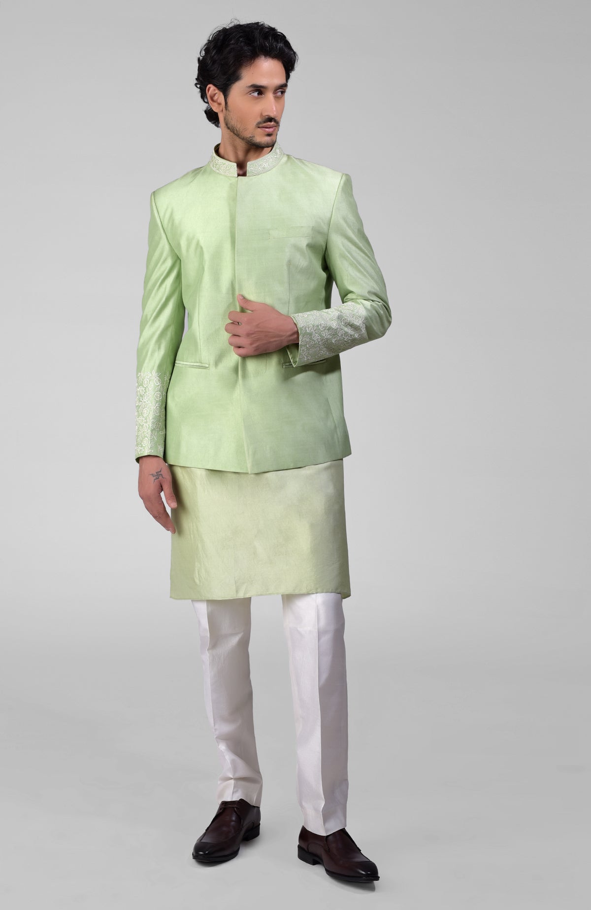 Sage green three-piece silk set with embroidered bandhgala jacket, kurta, and pants.