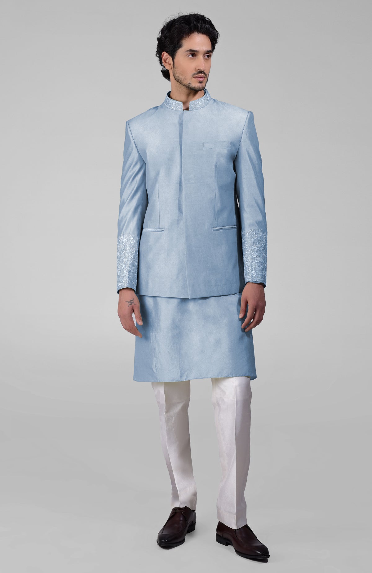 Dusty blue silk three-piece set with embroidered bandhgala jacket, kurta, and pants.