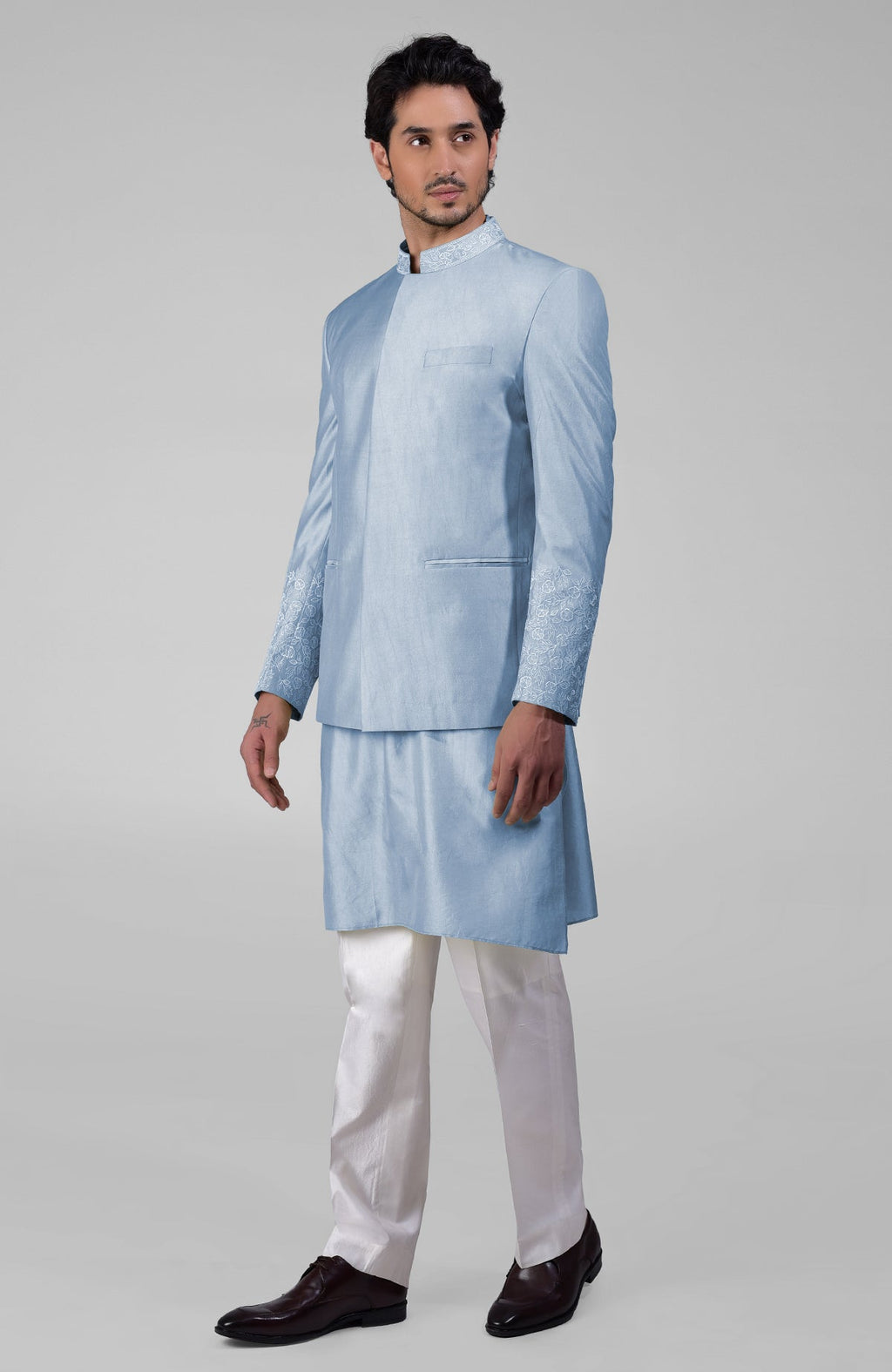 Dusty blue silk three-piece set with embroidered bandhgala jacket, kurta, and pants.