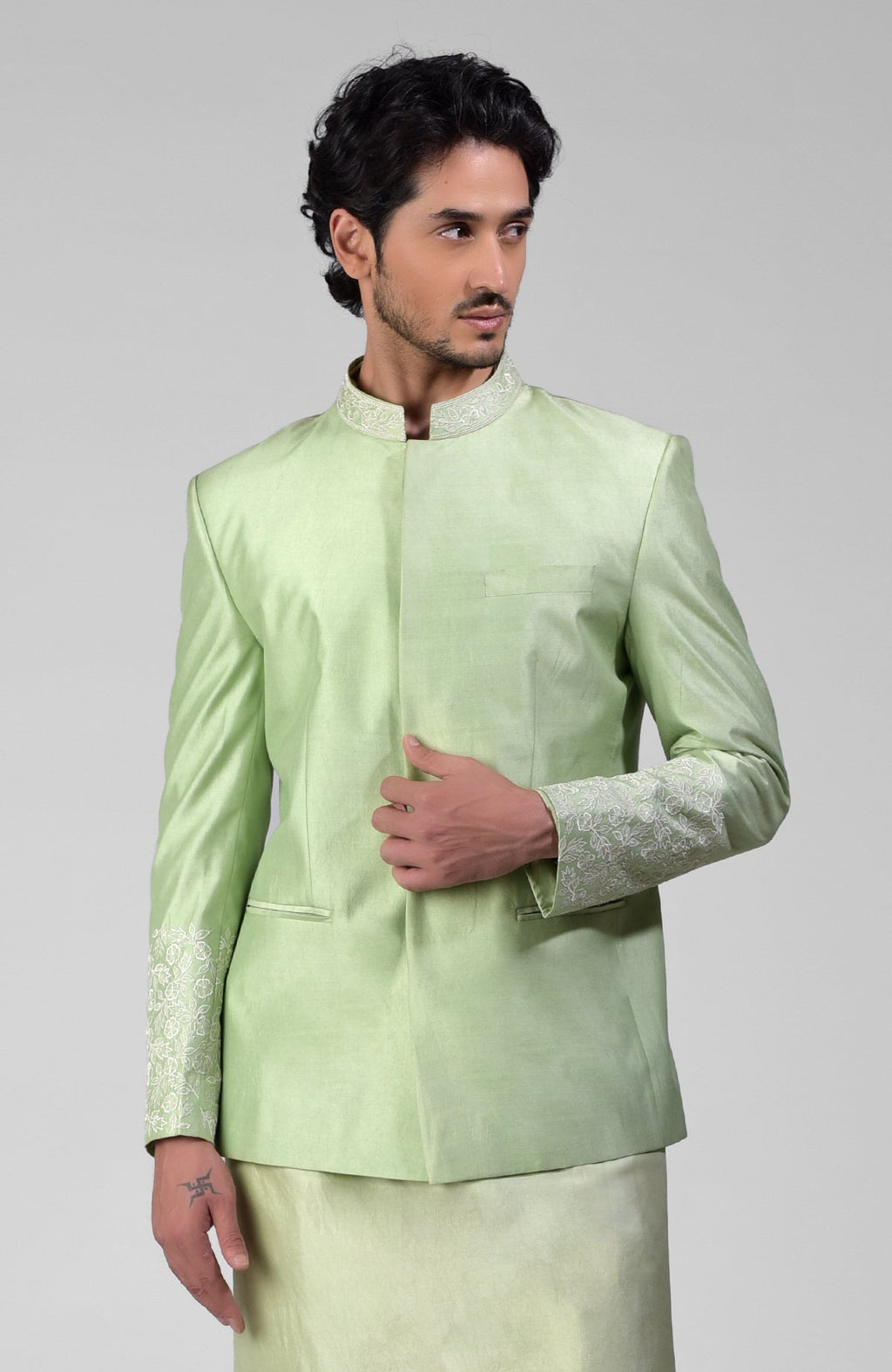 Sage green three-piece silk set with embroidered bandhgala jacket, kurta, and pants.