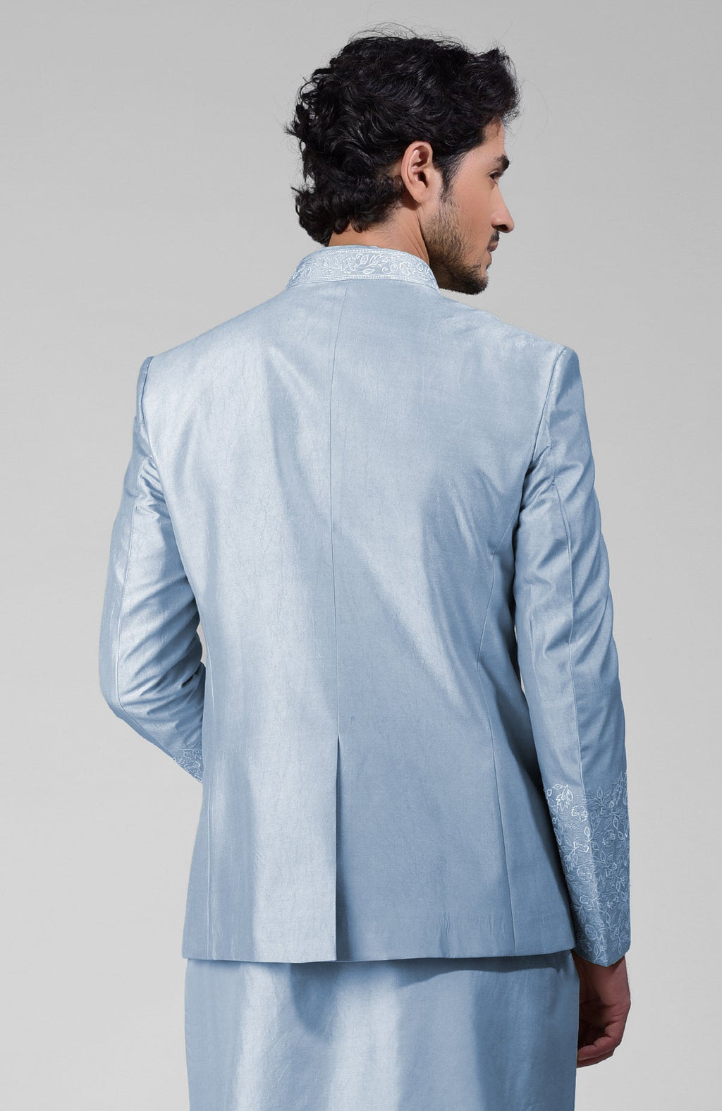 Dusty blue silk three-piece set with embroidered bandhgala jacket, kurta, and pants.