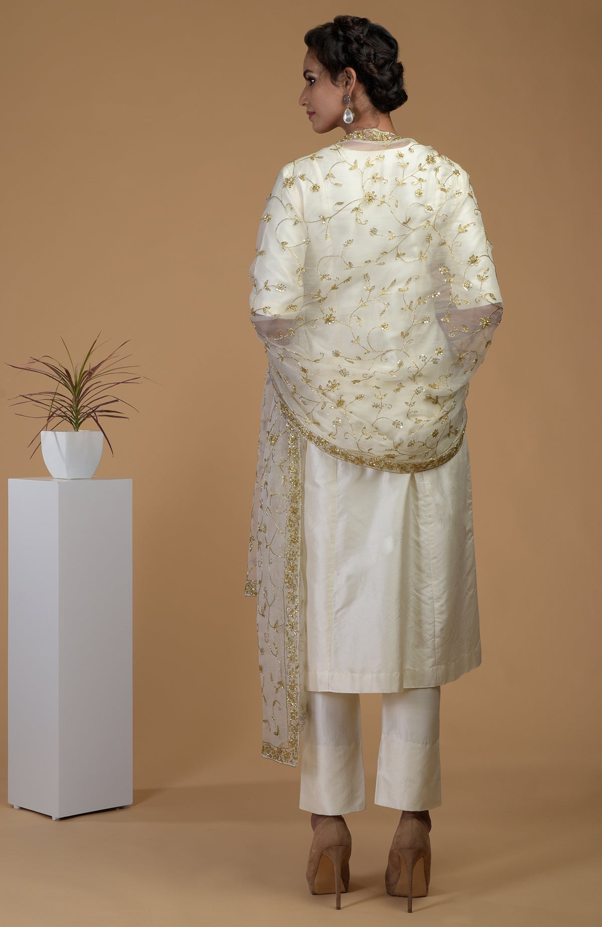 Woman in an ivory-gold zardozi hand-embroidered dupatta with a matching suit.