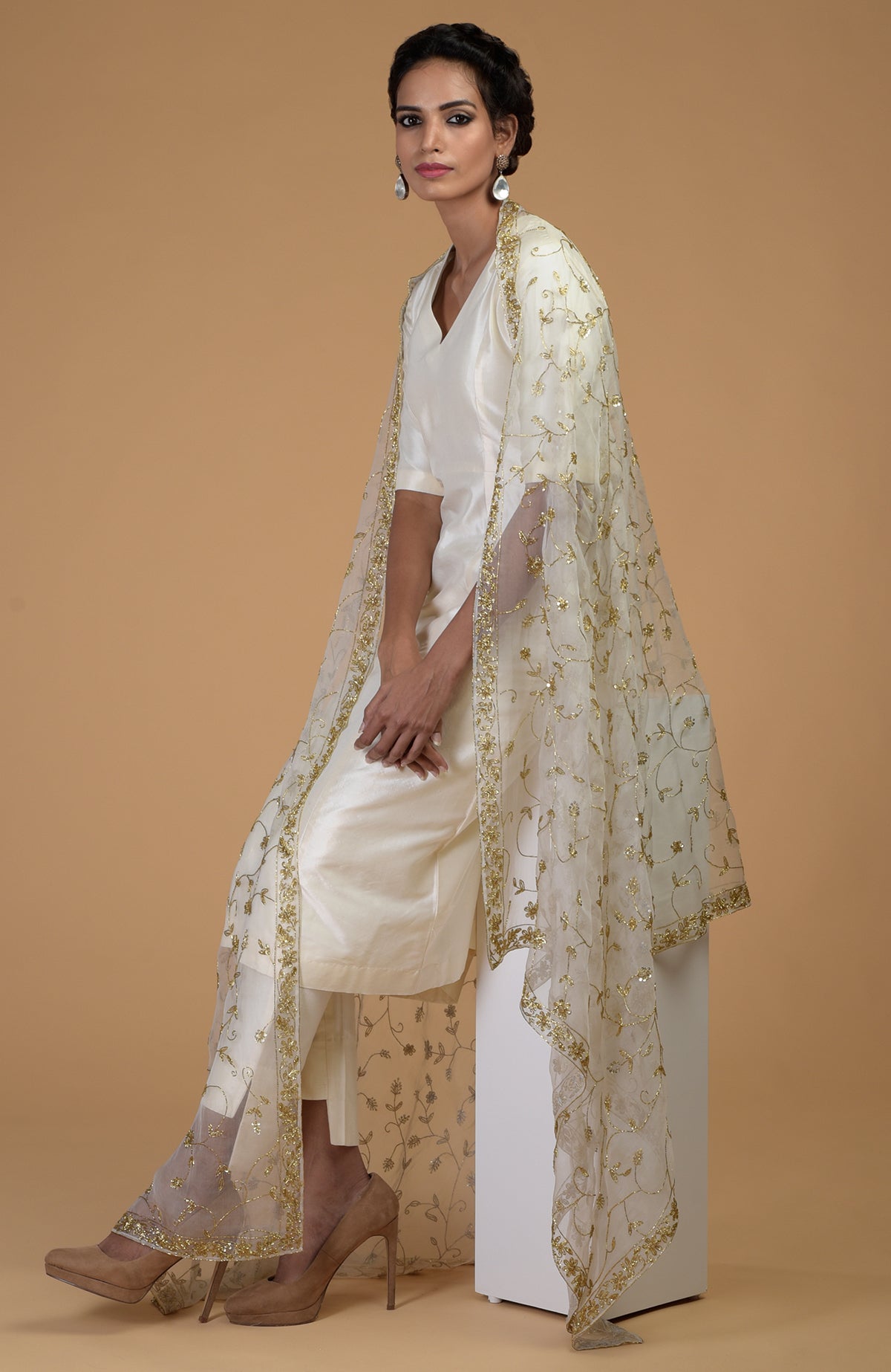 A woman models an ivory-gold zardozi hand-embroidered dupatta with a matching suit.