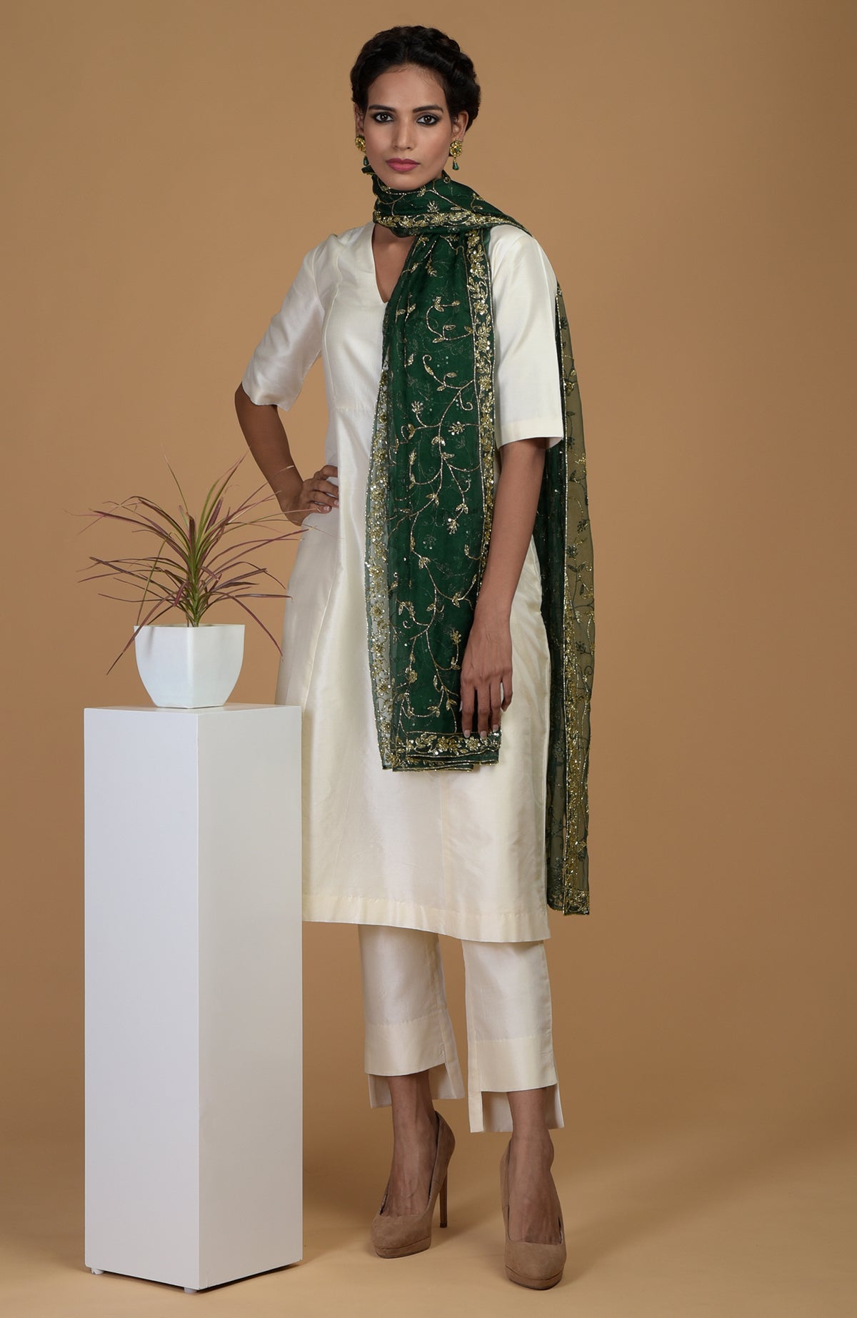 An emerald green zardozi hand-embroidered dupatta with a cream suit.