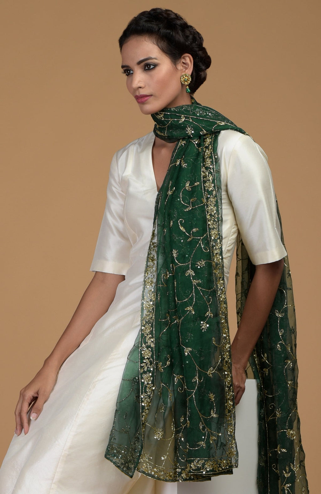 Woman in an ivory suit with an emerald green zardozi hand-embroidered dupatta.