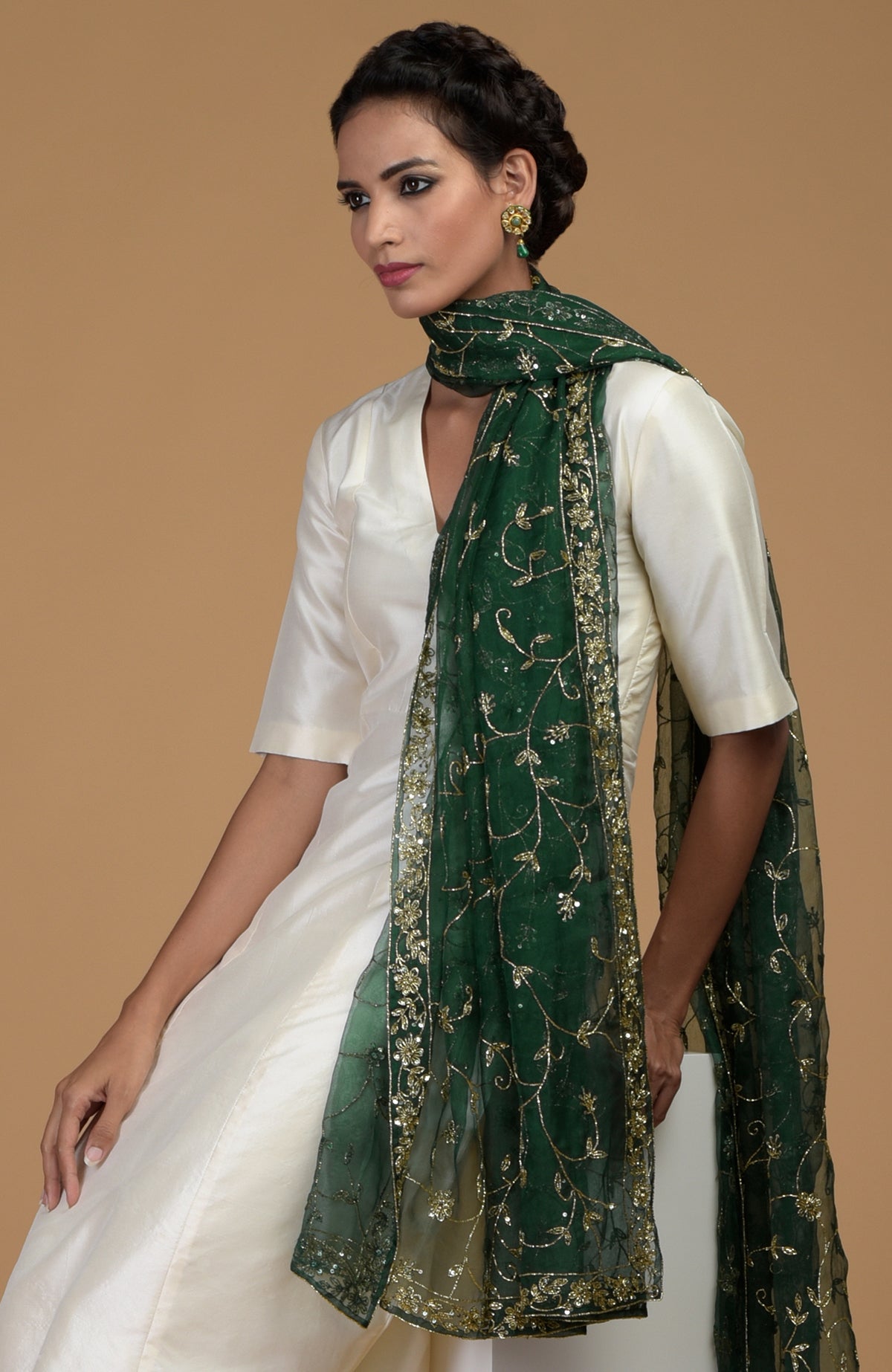 Woman in an ivory suit with an emerald green zardozi hand-embroidered dupatta.