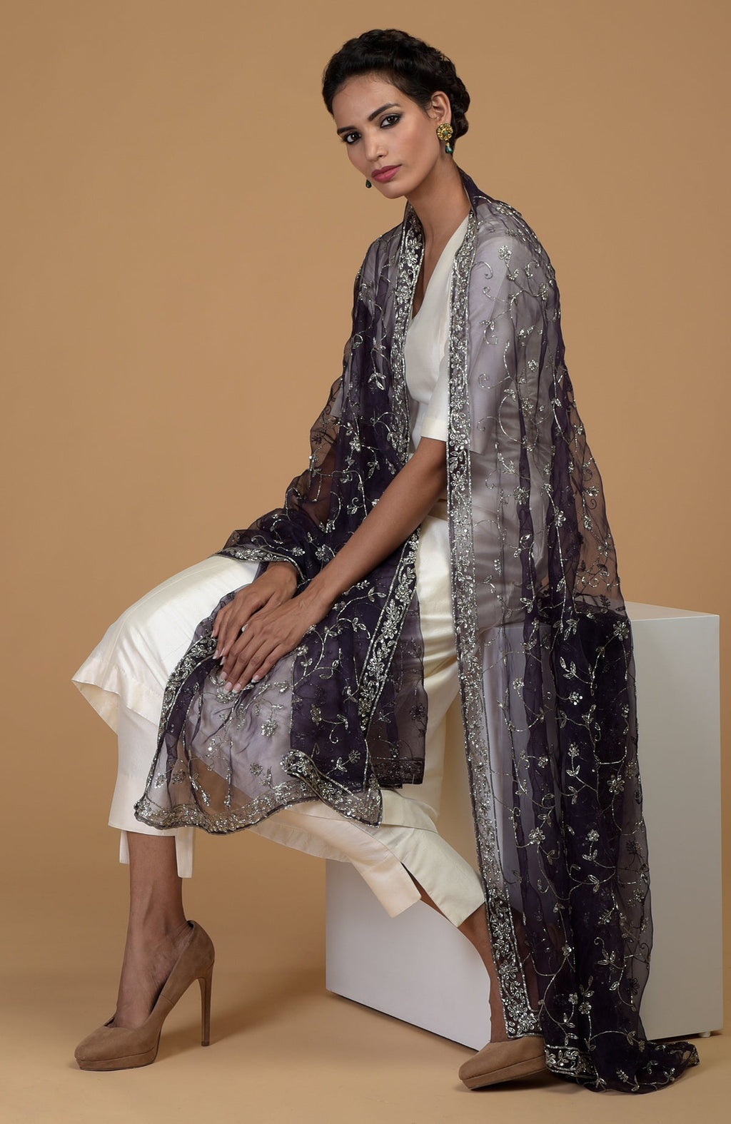 An eclipse blue zardozi hand embroidered dupatta with a white suit.
