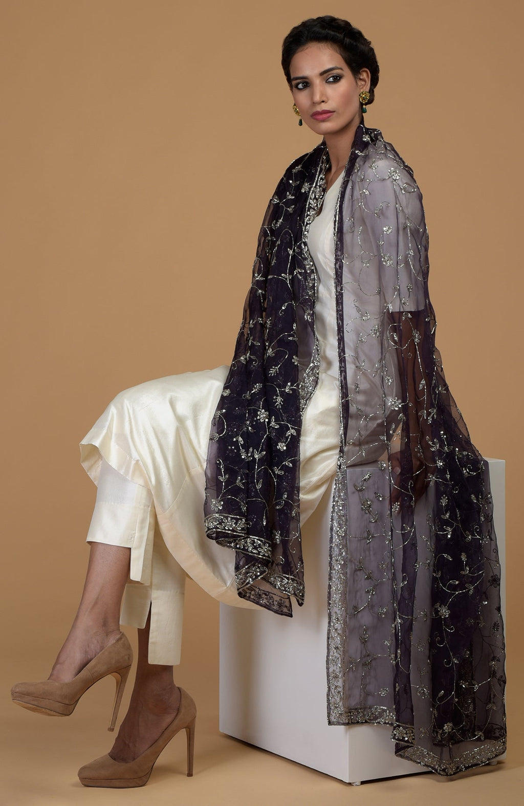 A woman models an eclipse blue zardozi hand-embroidered dupatta with a cream suit.