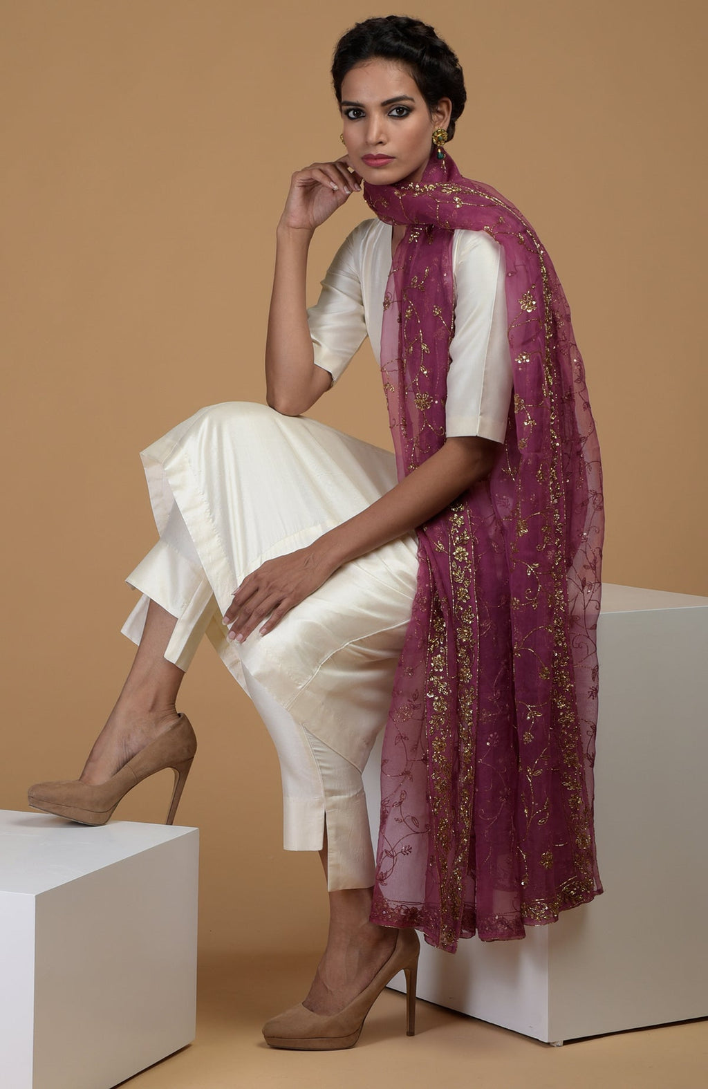 A woman models a peacock pink zardozi hand embroidered dupatta with a suit.