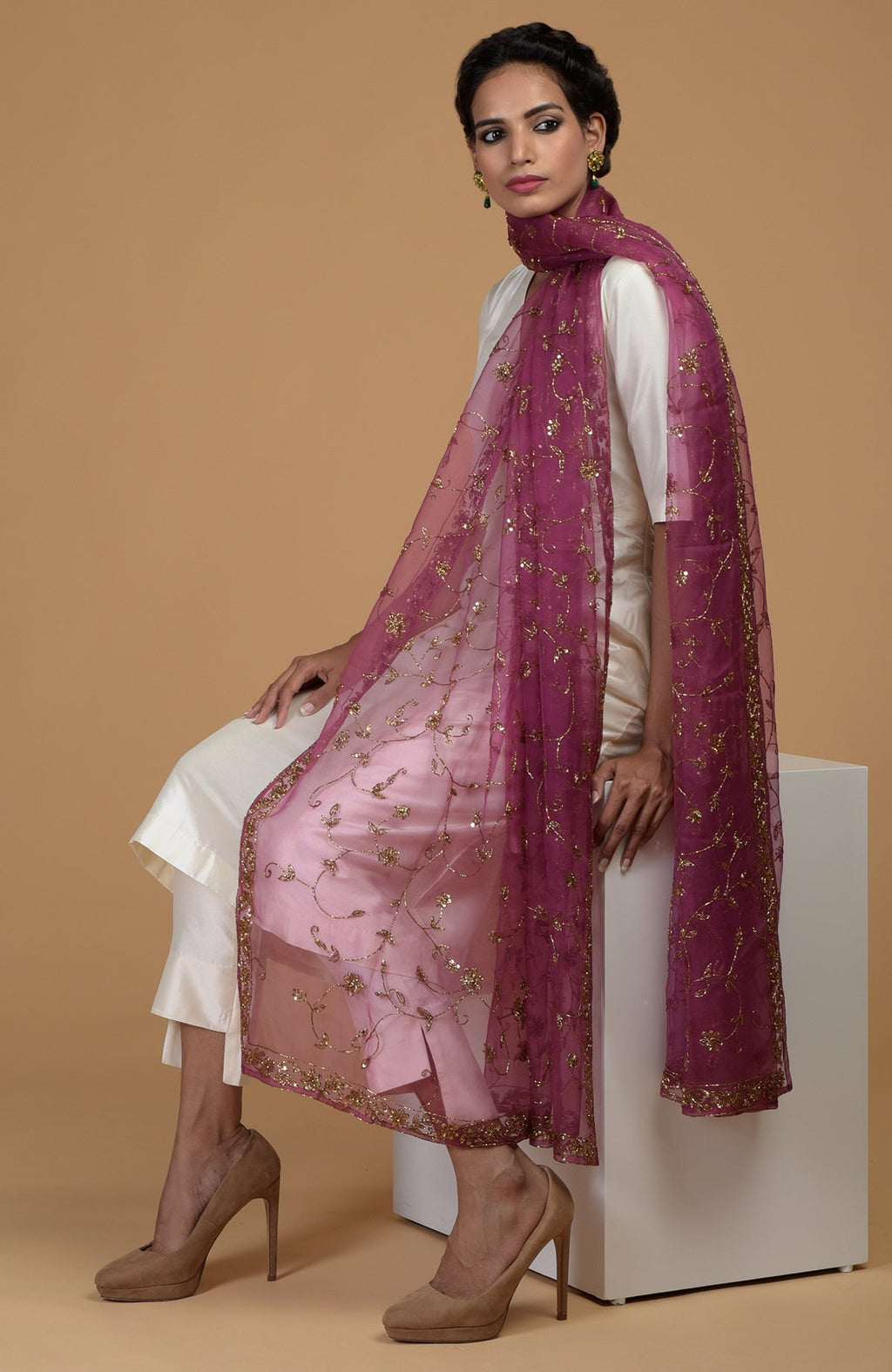 A woman models a peacock pink zardozi hand-embroidered dupatta with a white suit.