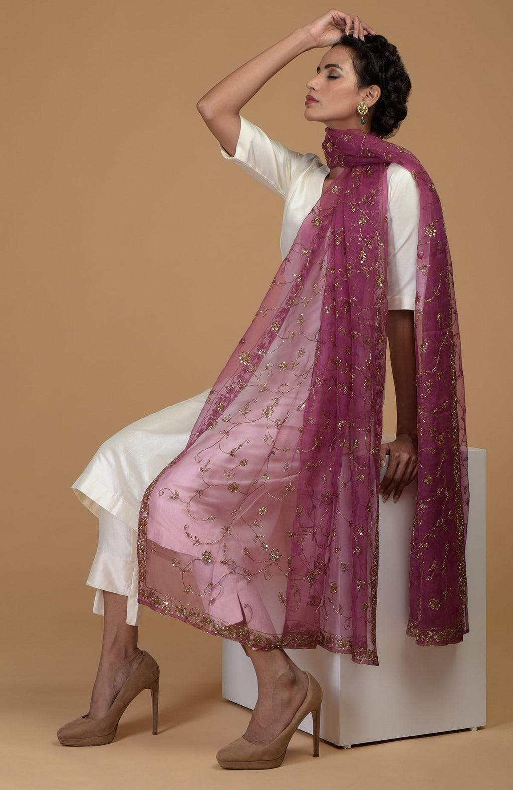 A woman models a peacock pink zardozi hand-embroidered dupatta with a suit.