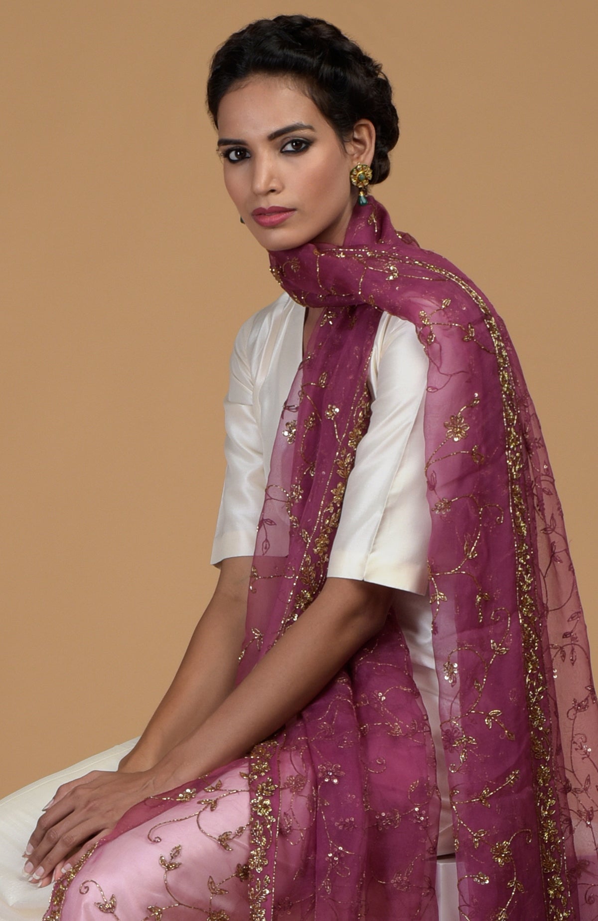 A woman models a peacock pink zardozi hand-embroidered dupatta with a suit.