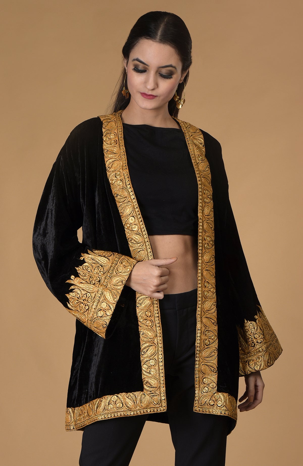 A woman models a black velvet kimono jacket with gold tilla embroidery.