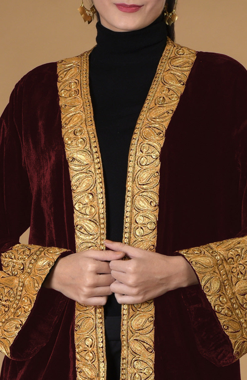Burgundy velvet kimono jacket with gold Kashmiri tilla embroidery, worn over a black top.