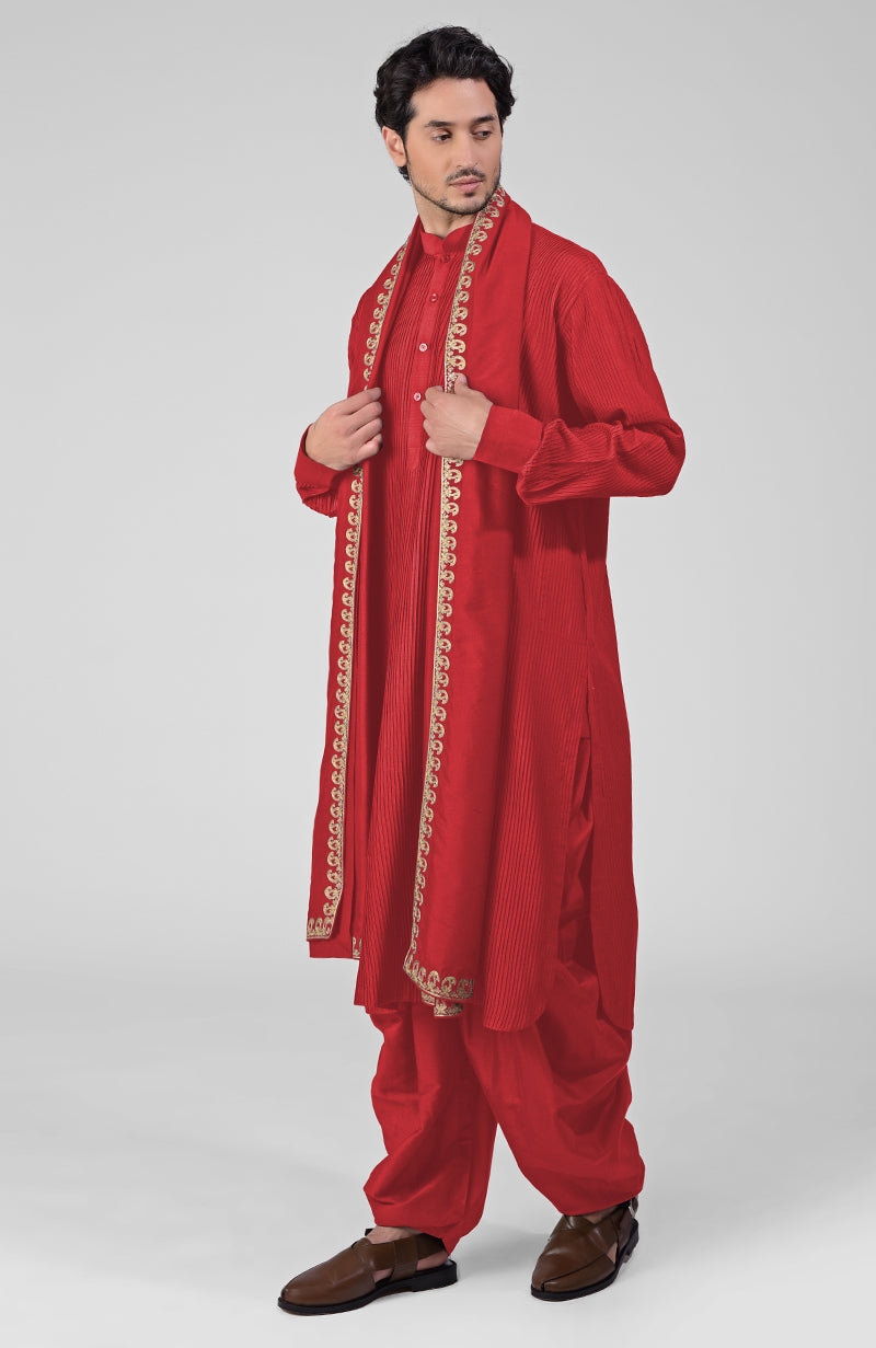 Scarlet red pintuck kurta with pathani salwar and gold tilla embroidered dupatta.