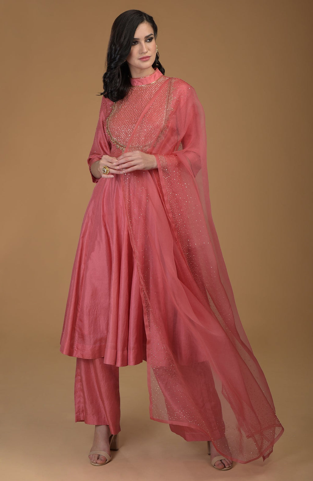 A woman models a peach echo kalidaar suit with zardozi hand embroidery.