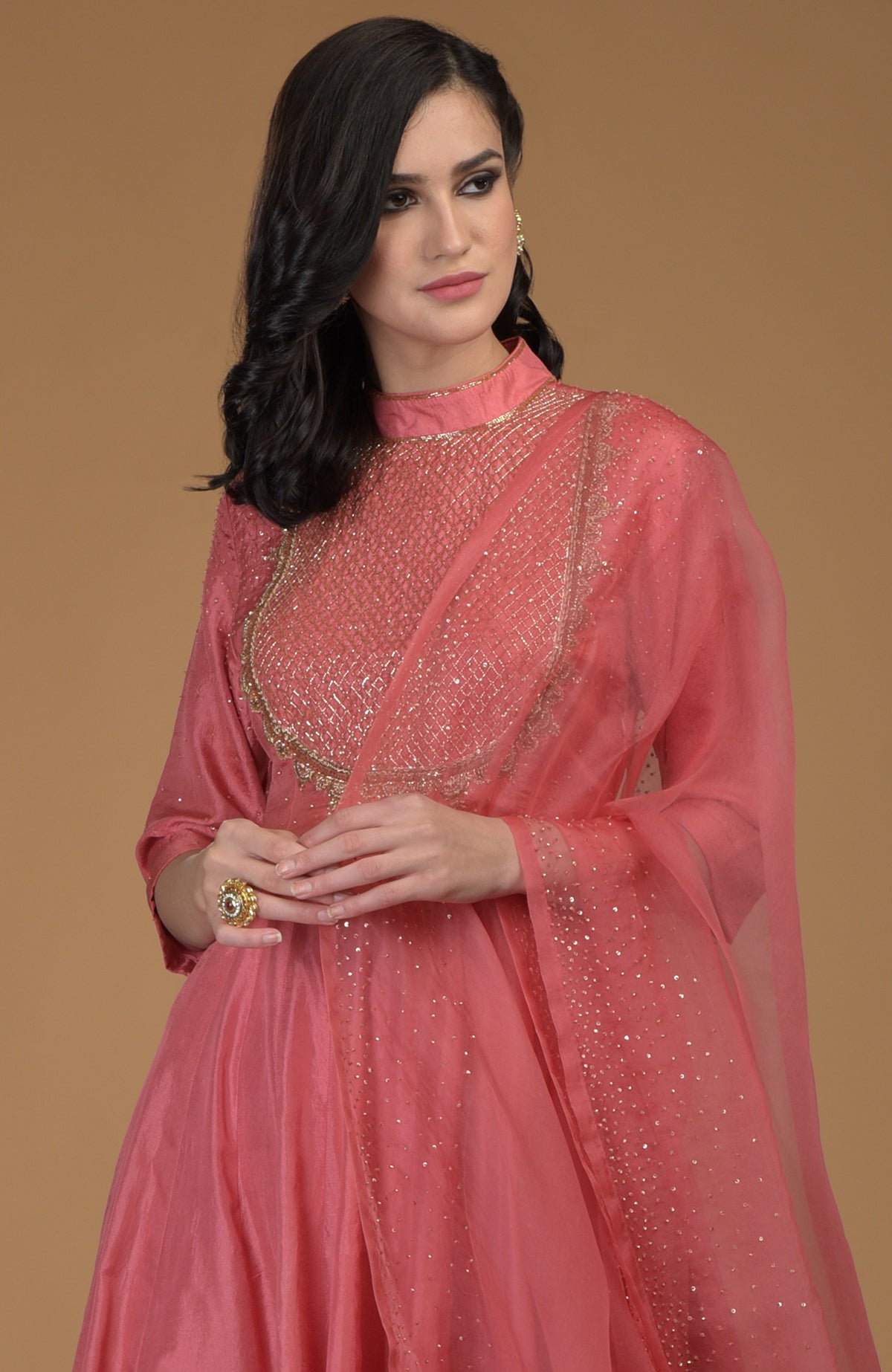 A woman models a peach echo kalidaar suit with zardozi hand embroidery.