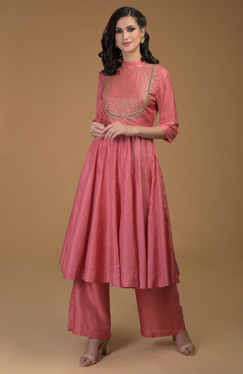 A woman models a peach kalidaar suit with zardozi hand embroidery.