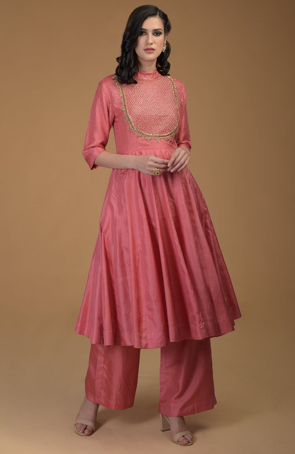A woman models a peach echo kalidaar suit with zardozi hand embroidery.
