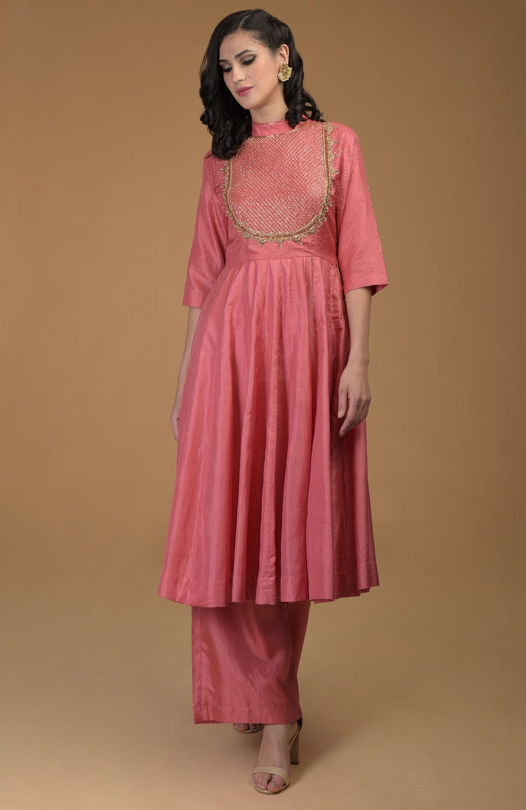 A woman models a peach echo kalidaar suit with zardozi hand embroidery.