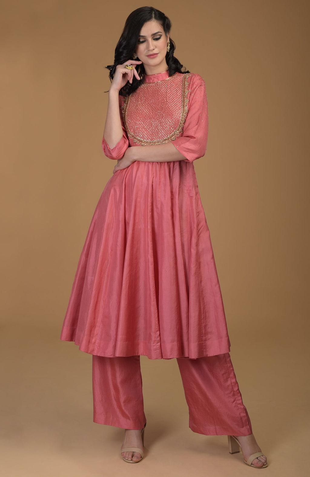 A woman models a peach echo kalidaar suit with zardozi hand embroidery.