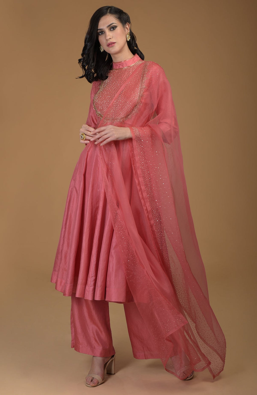 A woman models a peach echo kalidaar suit with zardozi embroidery and a sheer dupatta.