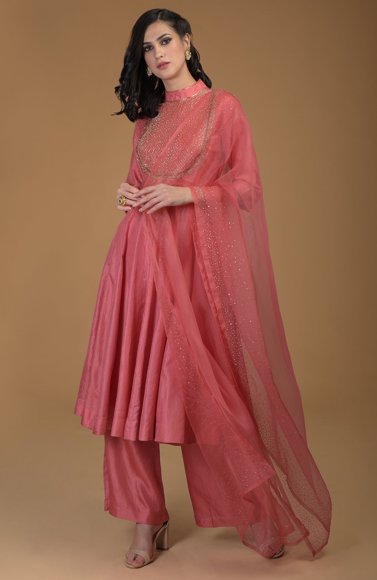A woman models a peach echo kalidaar suit with zardozi embroidery and a sheer dupatta.