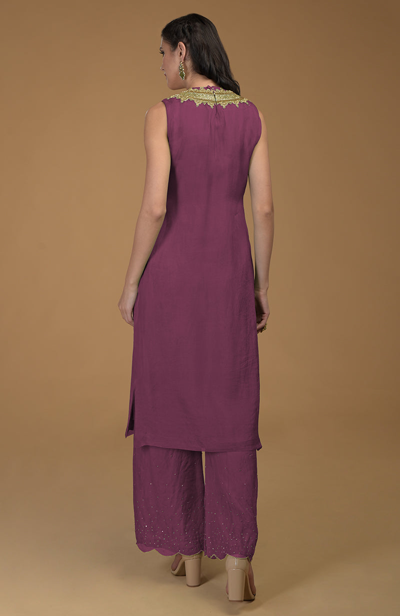 A woman models a burgundy purple kurta set with zardozi embroidery.