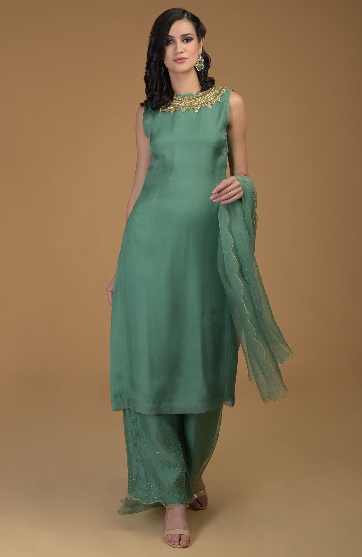 A woman models a green zardozi hand-embroidered kurta set with wide-leg pants and a dupatta.