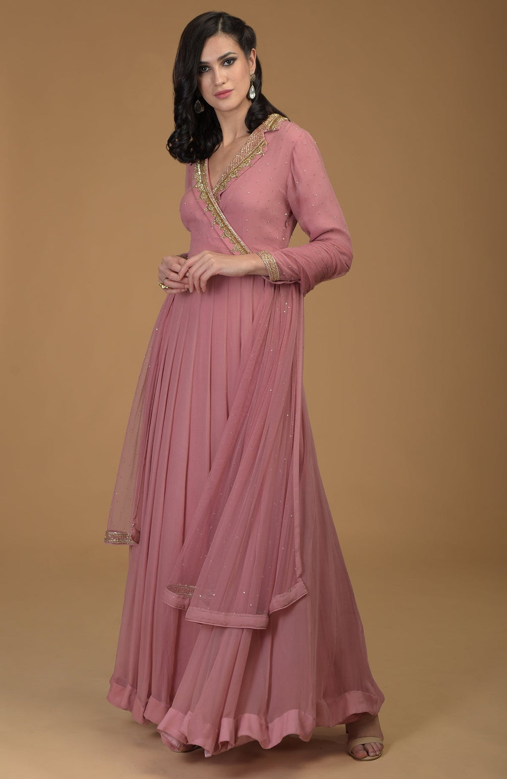 A woman models a withered rose kalidaar dress with gold zardozi embroidery.