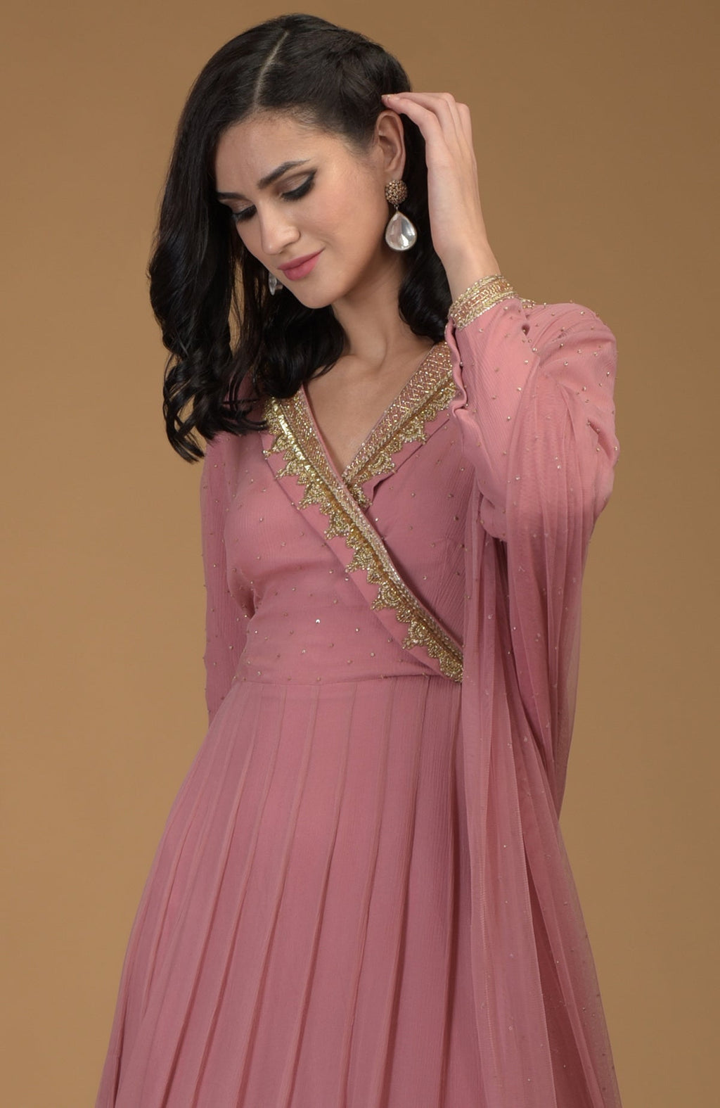 A woman models a withered rose kalidaar dress with gold zardozi embroidery.