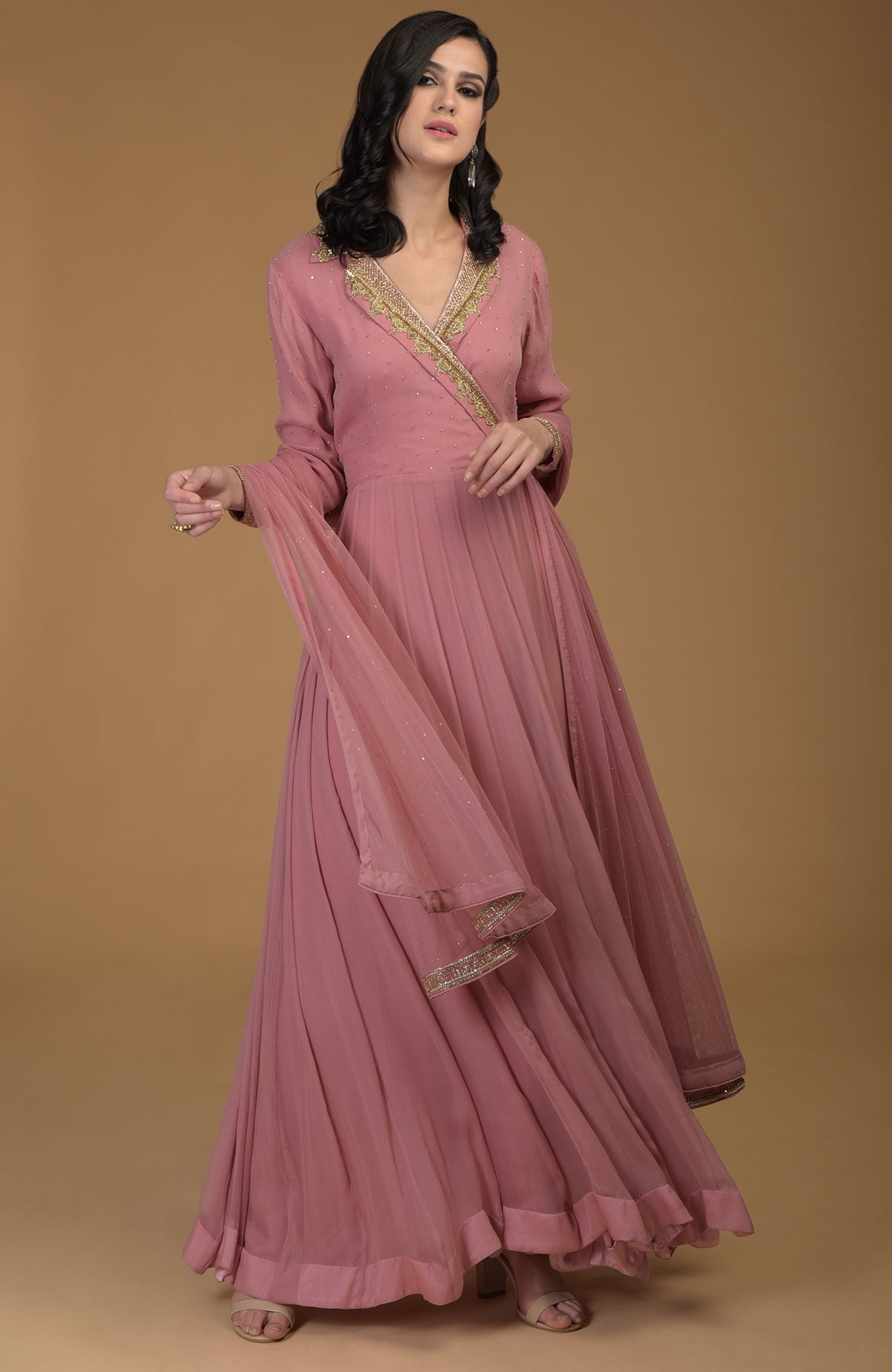 A woman models a withered rose kalidaar dress with gold zardozi embroidery.