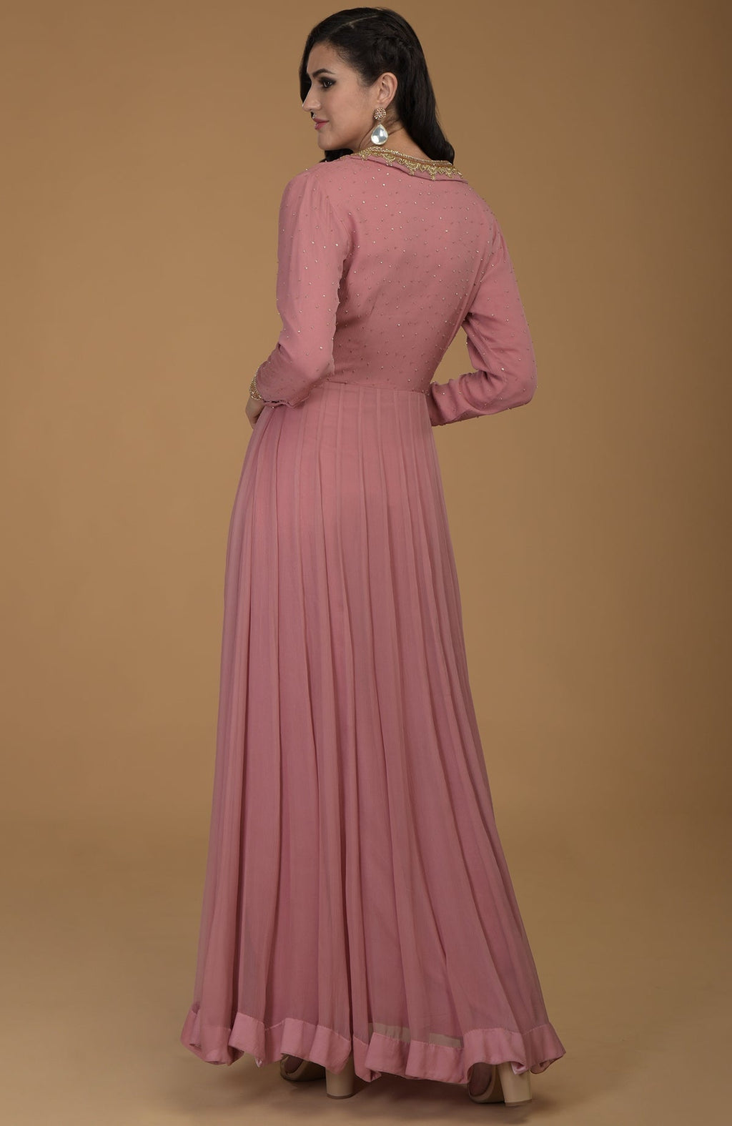 A woman models a withered rose kalidaar dress with gold zardozi embroidery.
