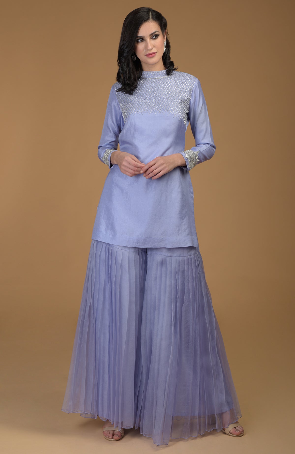 A woman models a pastel lilac kurta with zardozi embroidery and pleated gharara pants.