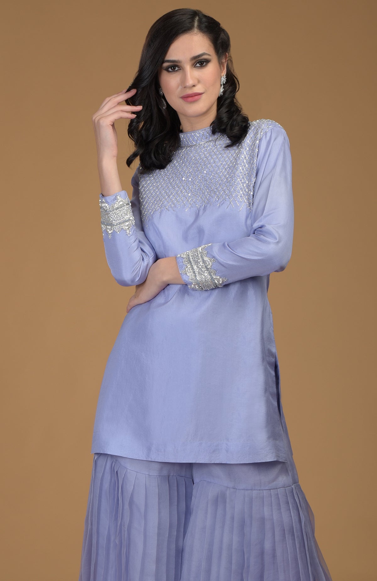 A woman models a pastel lilac kurta with zardozi embroidery and pleated gharara pants.