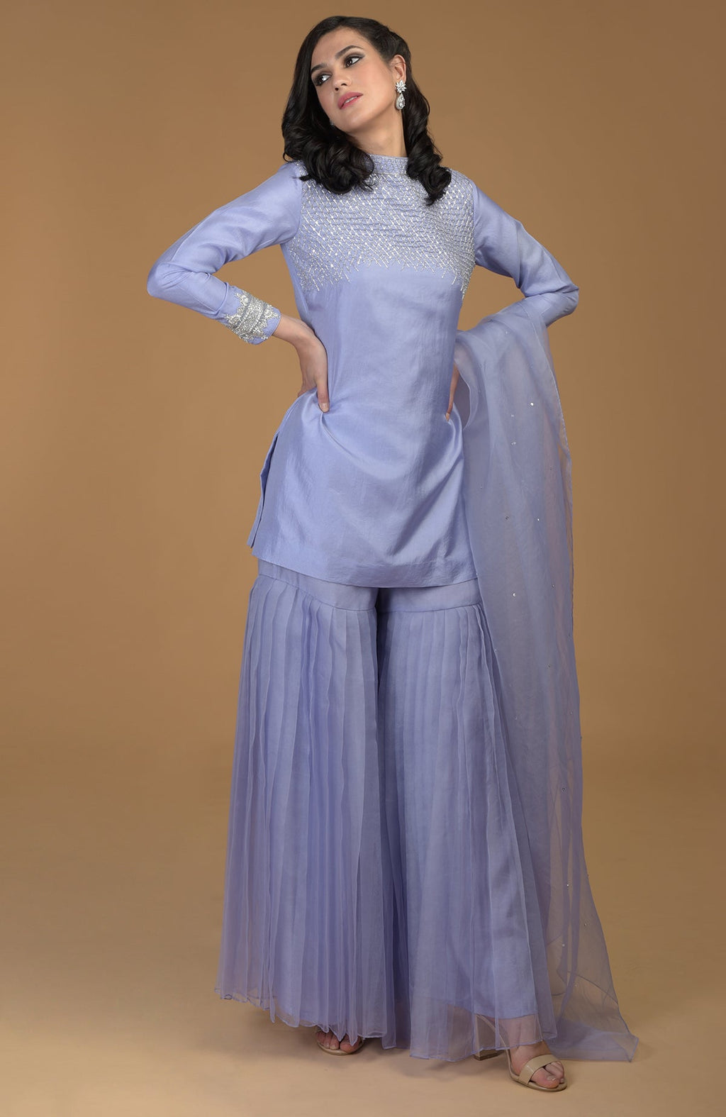 A woman models a pastel lilac zardozi hand-embroidered gharara set.