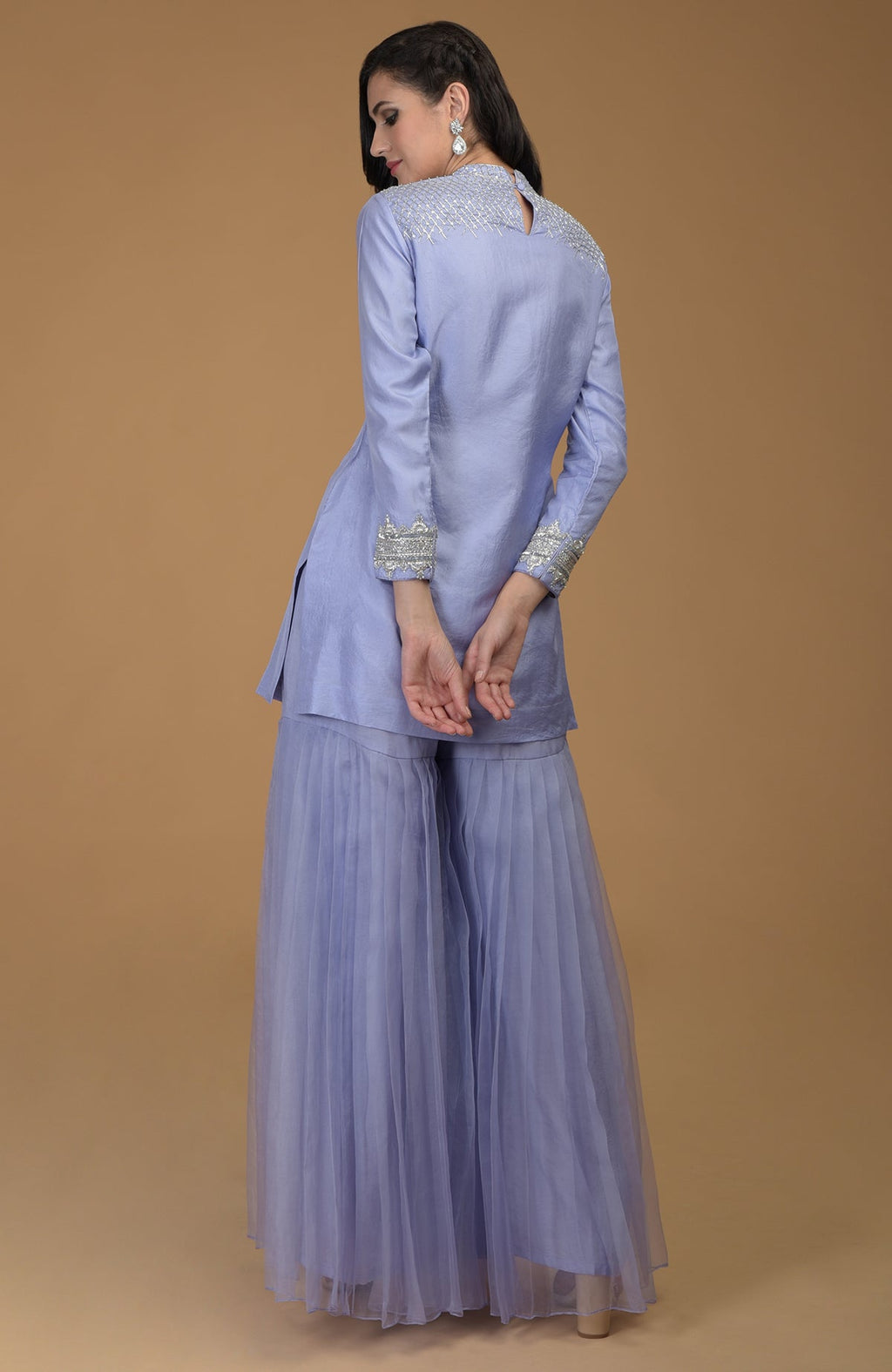 A woman models a pastel lilac gharara set with zardozi embroidery.